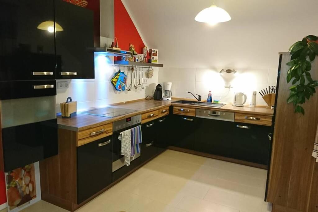 een keuken met houten werkbladen en een zwarte koelkast bij Ferienwohnung Schwedt Kastanienhöfe in Schwedt