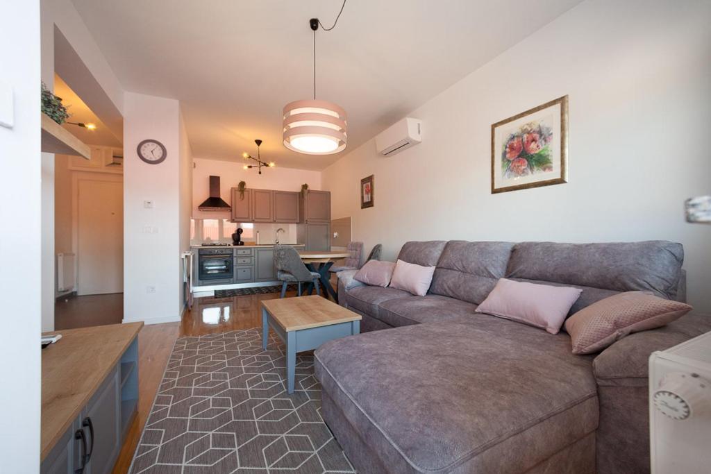a living room with a couch and a table at Apartman Pepper in Osijek
