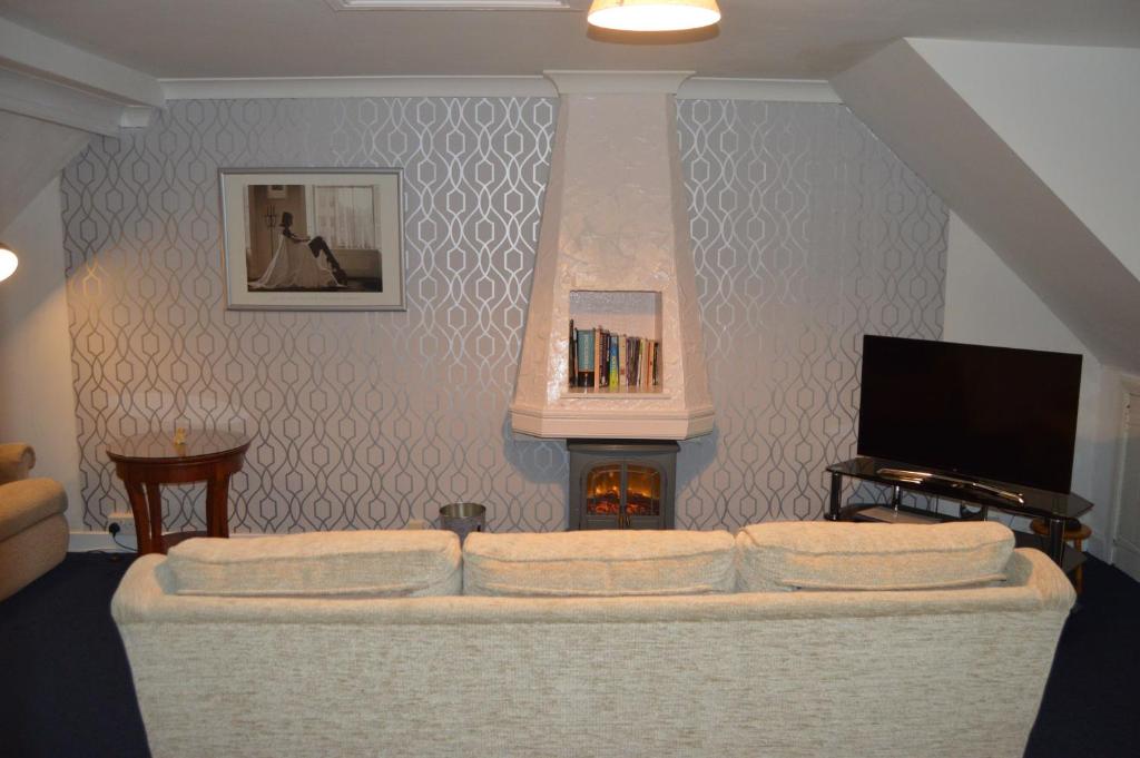 a living room with a couch and a fireplace at Holiday Apartment Dunfermline in Dunfermline