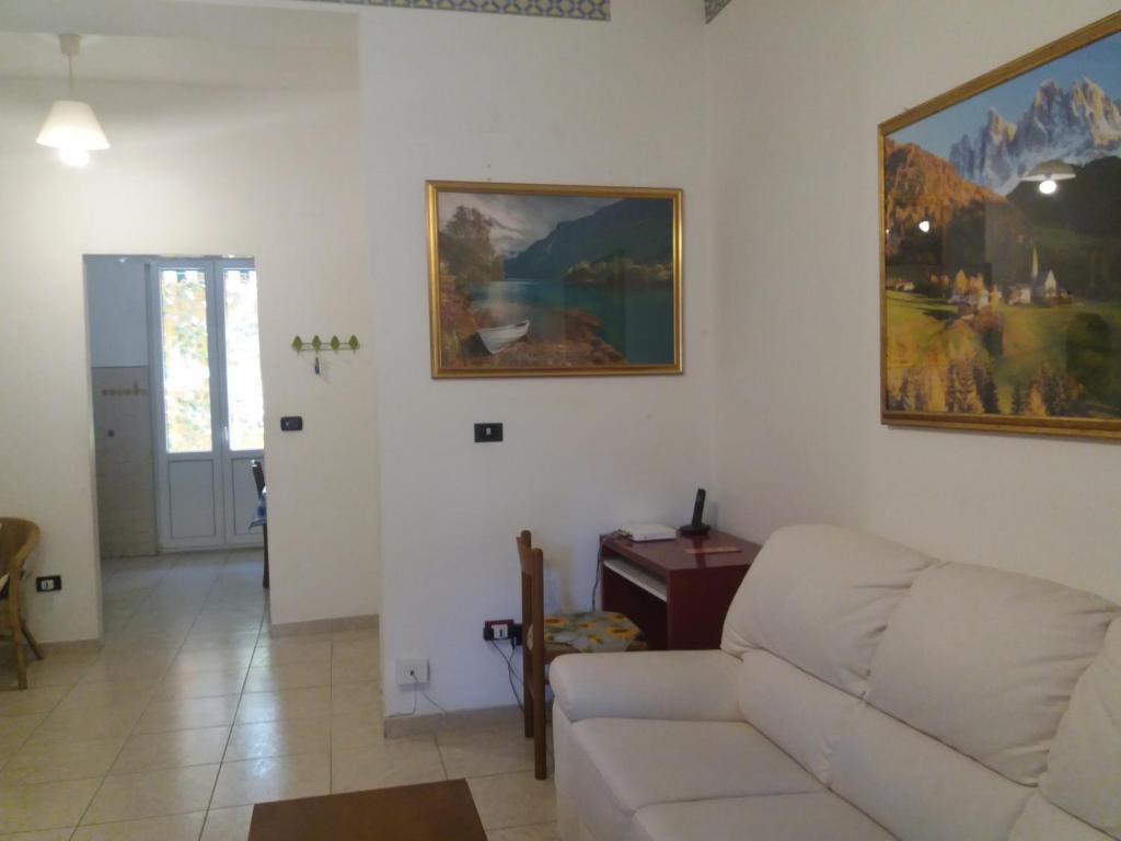 un salon avec un canapé blanc et un tableau mural dans l'établissement Casa vacanze Lida, à Marina di Carrara