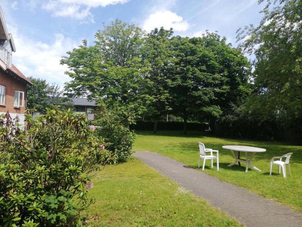 a table and chairs in a yard with a path at 300 meter walk to Lego house - Door 9 in Billund