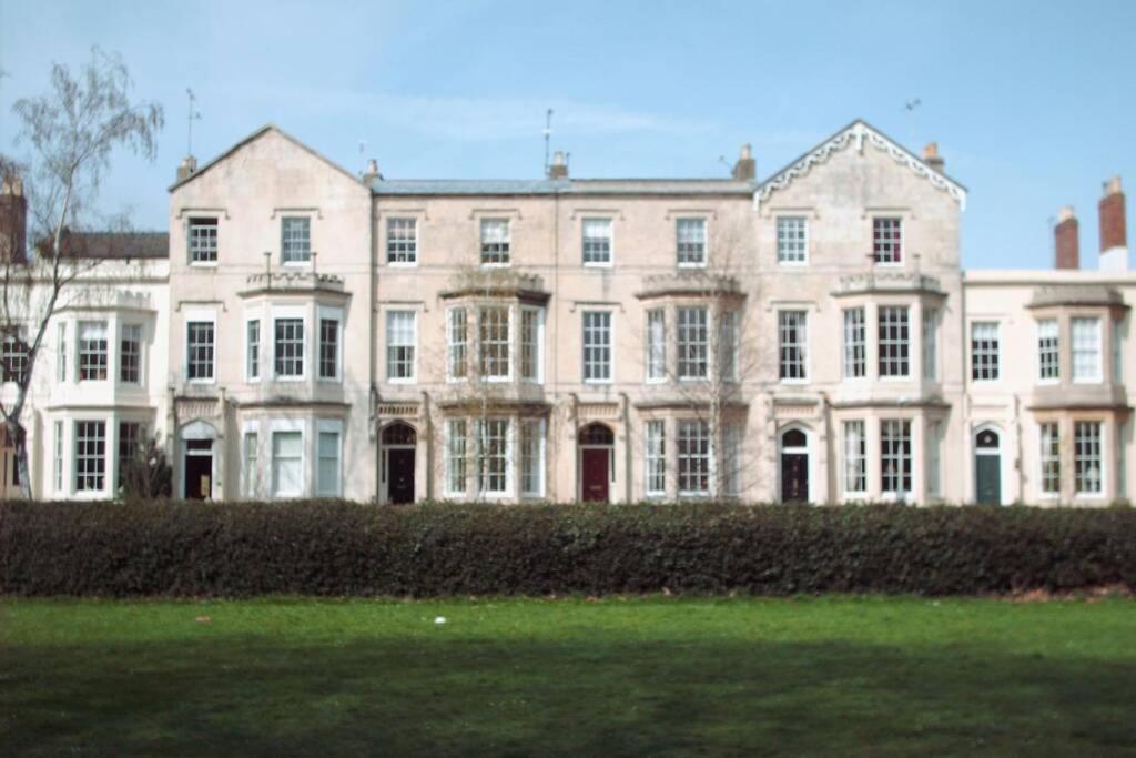 a large white building with a grass field in front of it at Central Cheltenham, Regency Apartment with PARKING, Cavalier Suite - Sleeps 6 in Cheltenham