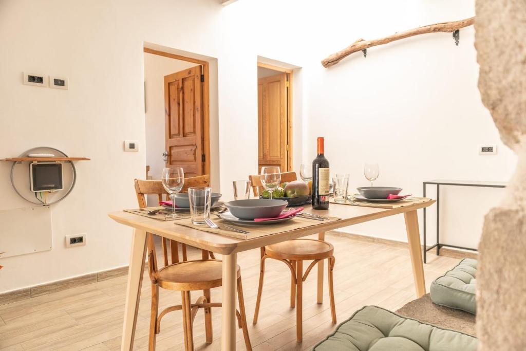 uma sala de jantar com uma mesa de madeira e copos de vinho em El blanquizal em San Nicolás