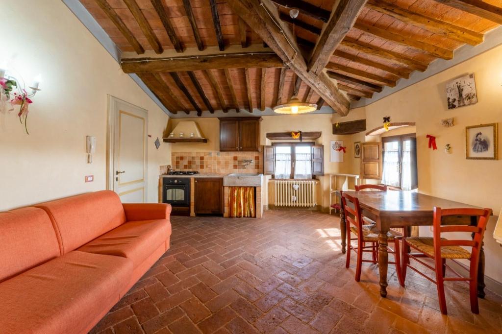 ein Wohnzimmer mit einem Sofa und einem Tisch in der Unterkunft The Cottage in Casciana Terme in Casciana Terme