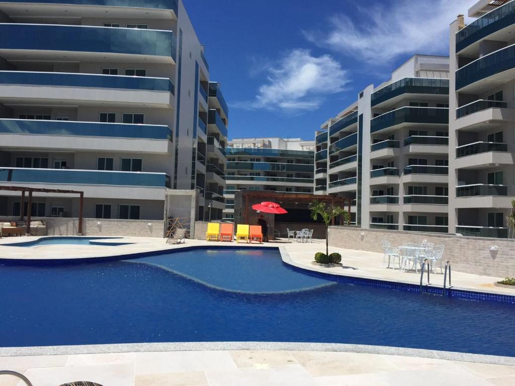 una gran piscina frente a algunos edificios en Praia Grande Le Bon Vivant 306, en Arraial do Cabo