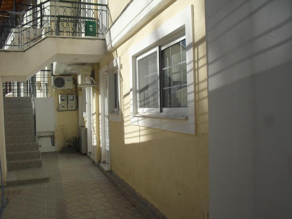 an empty hallway with a window and stairs on a building at Ανεξάρτητη γκαρσονιέρα κοντά στο κέντρο της Πάτρας in Patra