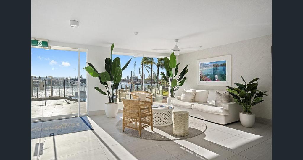 a living room filled with furniture and a large window at Silverton Apartment Resort Surfers Paradise in Gold Coast