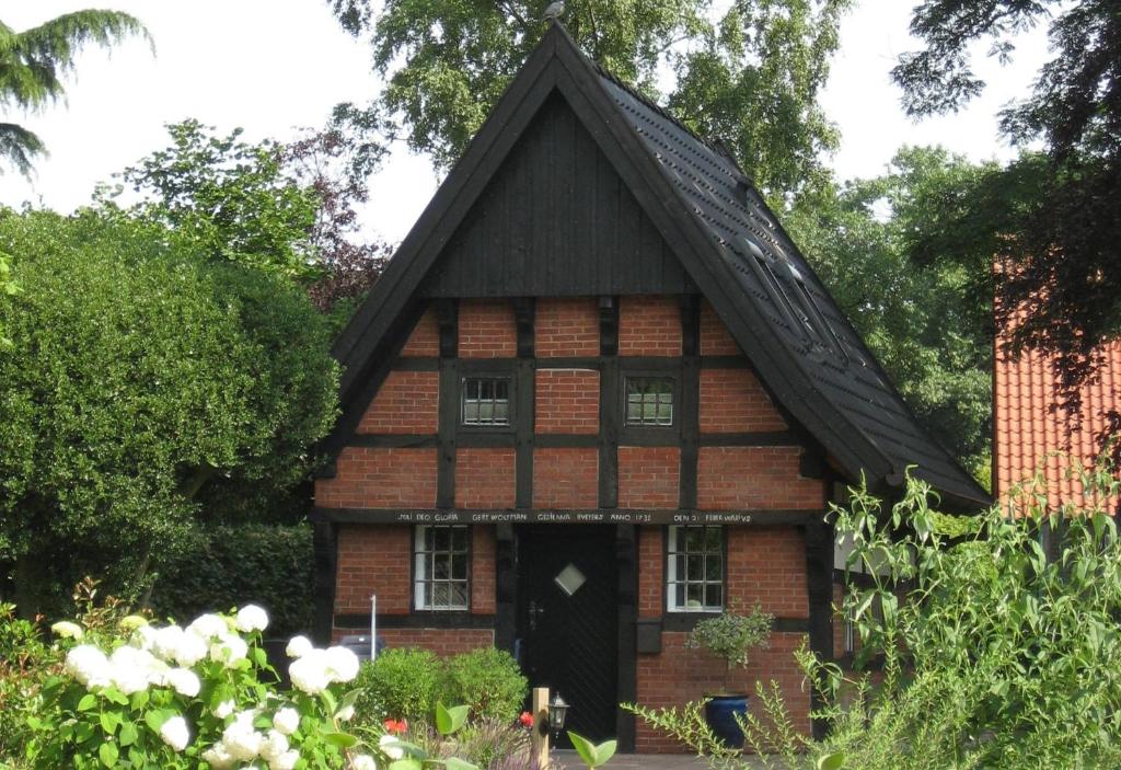 uma pequena casa de tijolos com um telhado preto em Backspieker BACK em Sögel