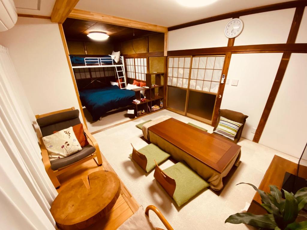 ein Wohnzimmer mit einem Tisch und einem Sofa in der Unterkunft 2nd House Family in Akimoto