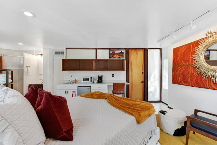 a bedroom with a white bed and a kitchen at The Loft By Pmi in Fort Lauderdale