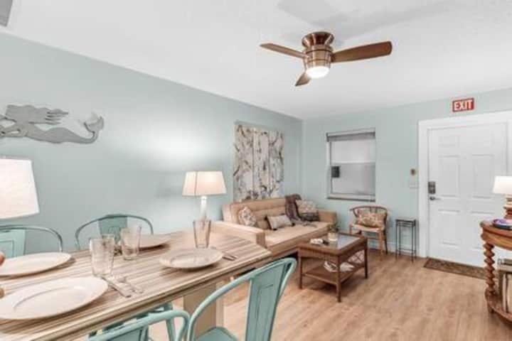 a living room with a table with chairs and a ceiling fan at Beach Apart By Pmi Unit 2 in West Palm Beach