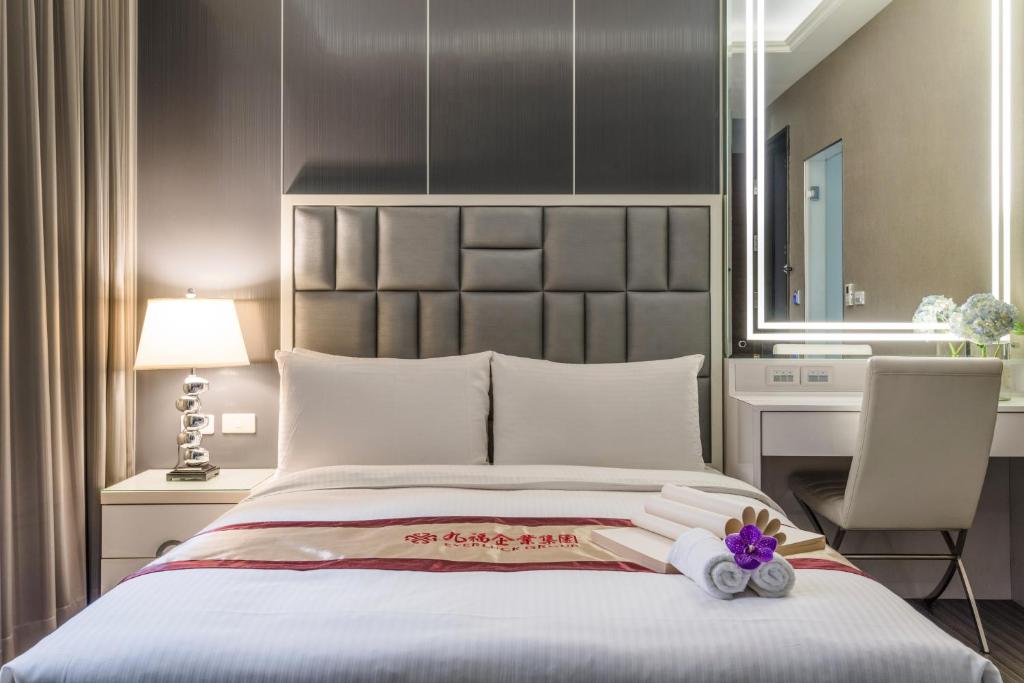 a bedroom with a large bed with a large headboard at Harmonious Hotel in Kaohsiung