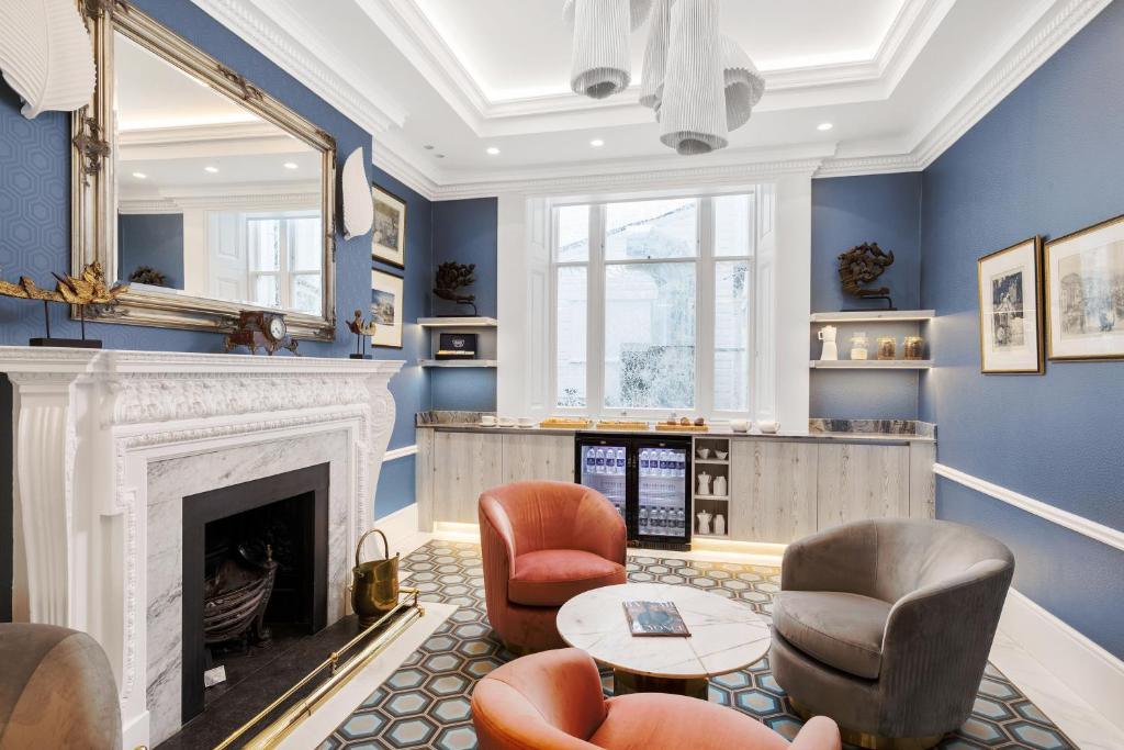 a living room with blue walls and a fireplace at Commodore Hotel in London