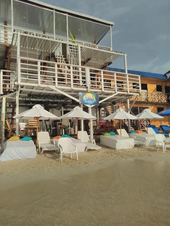 un grupo de sillas y sombrillas en una playa en posada donde Uriel Playa tranquila, en Barú