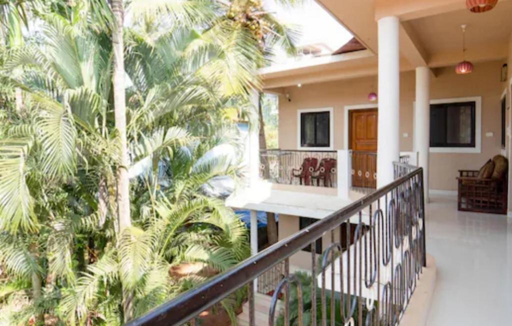 un balcón de una casa con palmeras en Esha Apartment, en Calangute