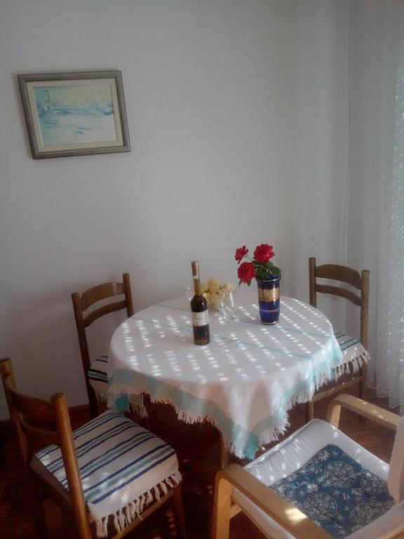 a table with a bottle of wine and flowers on it at Apartman Brazil in Bihać
