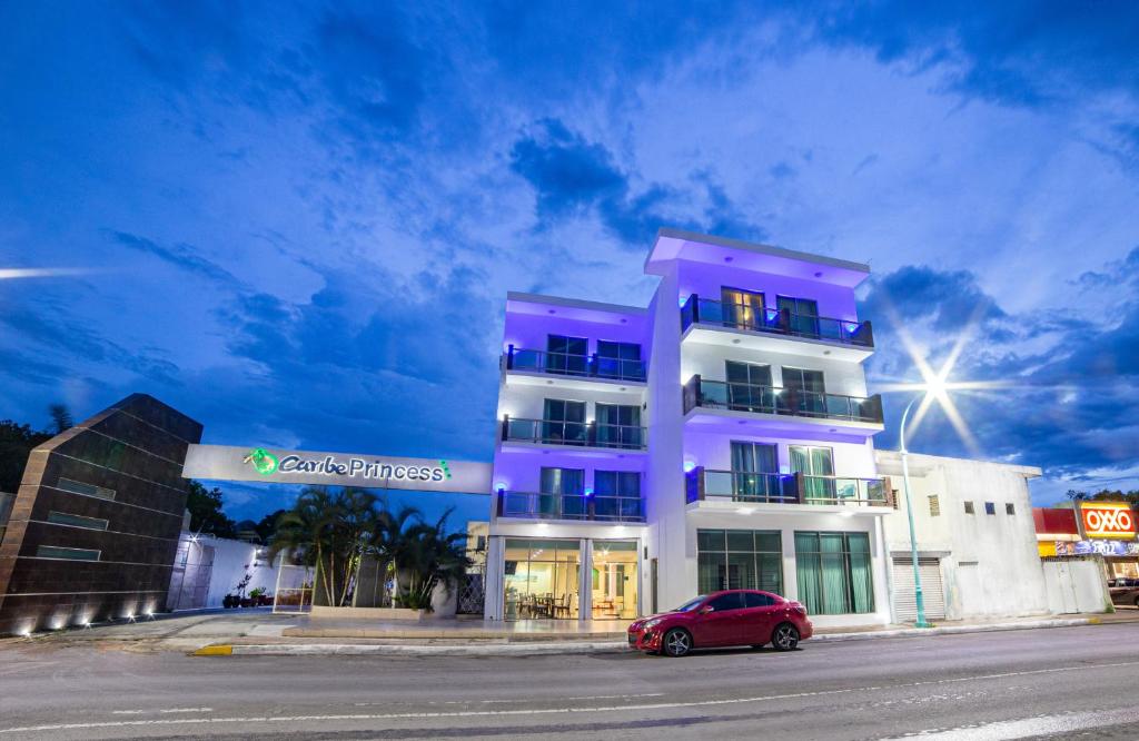 a red car parked in front of a purple building at Caribe Princess in Chetumal