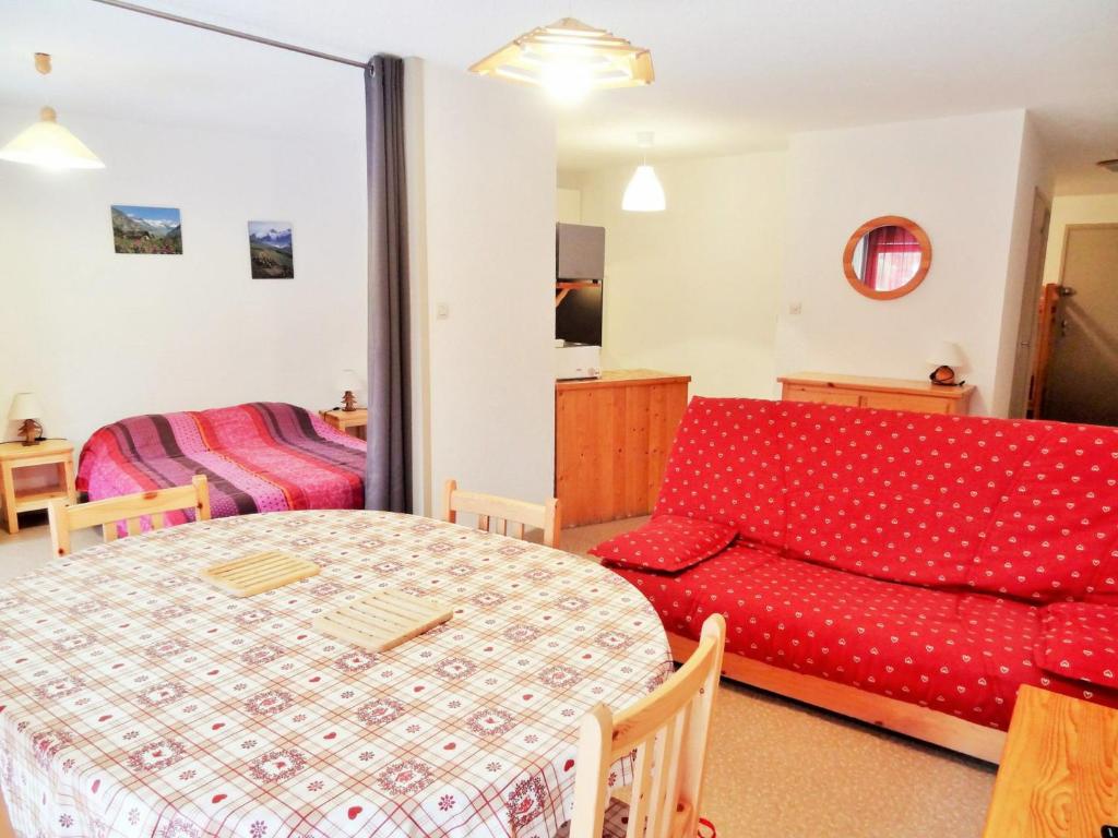 a living room with a red couch and a table at Appartement Les Deux Alpes, 2 pièces, 6 personnes - FR-1-516-2 in Les Deux Alpes