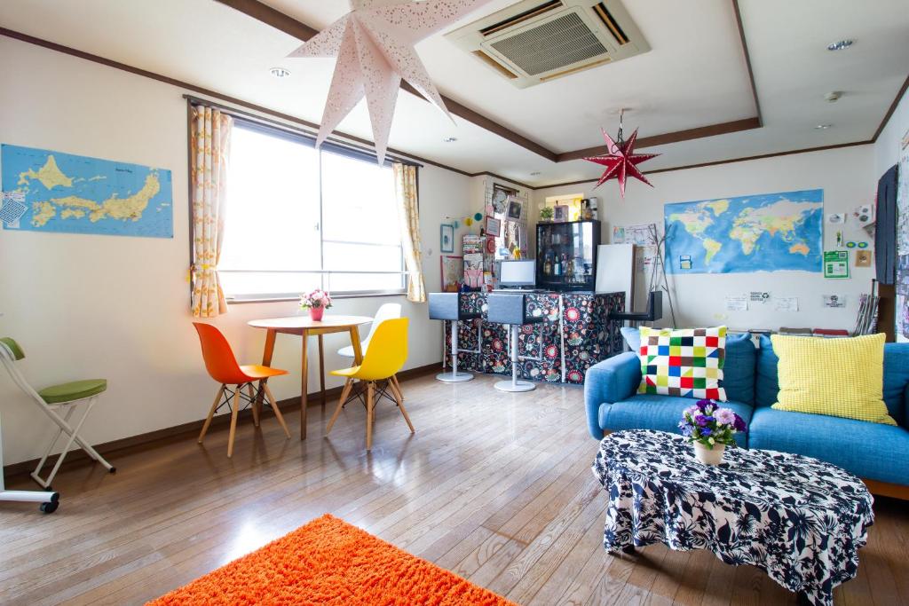 a living room with a blue couch and a table at OD ゲストハウスTSUU小田原 Guest House Tsuu Odawara in Odawara