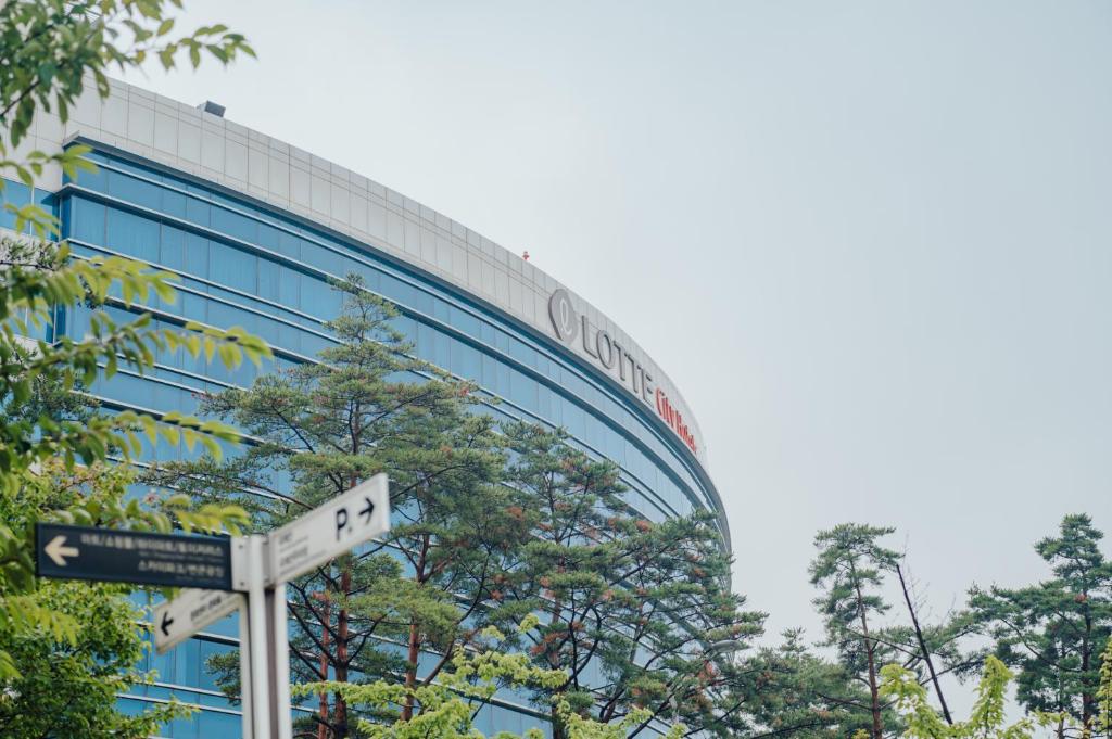 a street sign in front of a glass building at LOTTE City Hotel Gimpo Airport in Seoul