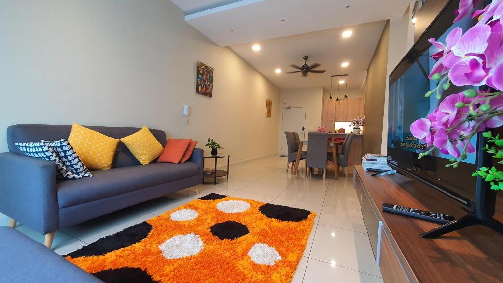 a living room with a couch and a tv at Southville Stay @ Savanna Executive Suite in Bangi