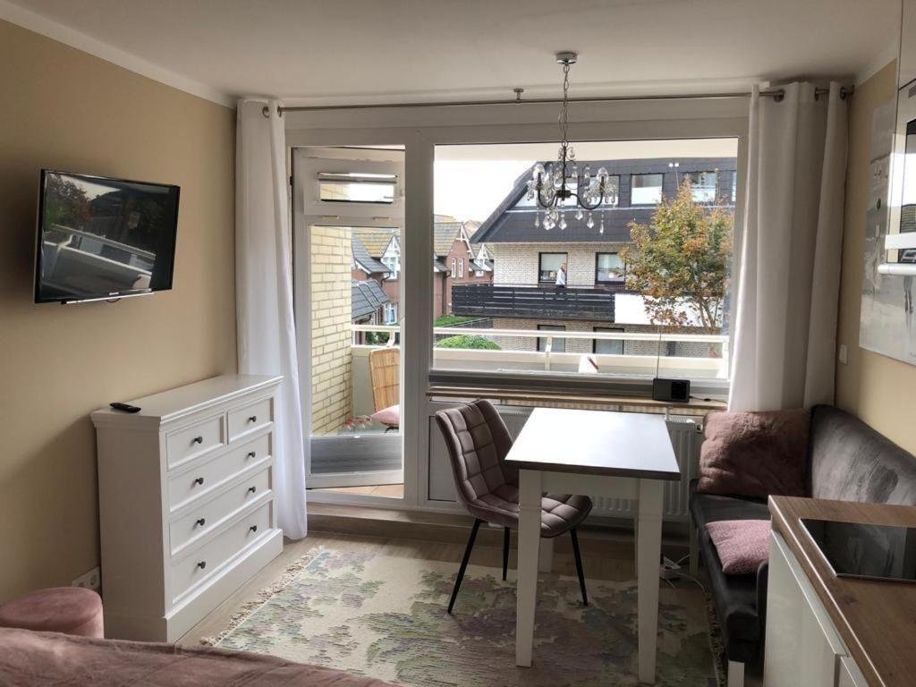 ein Wohnzimmer mit einem Tisch und einem Fenster in der Unterkunft Seerose in Westerland
