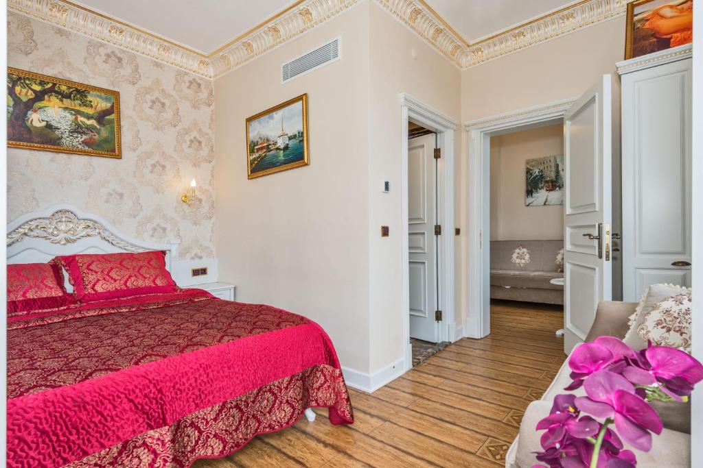 um quarto com uma cama vermelha e um sofá em IQ Hotel em Istambul