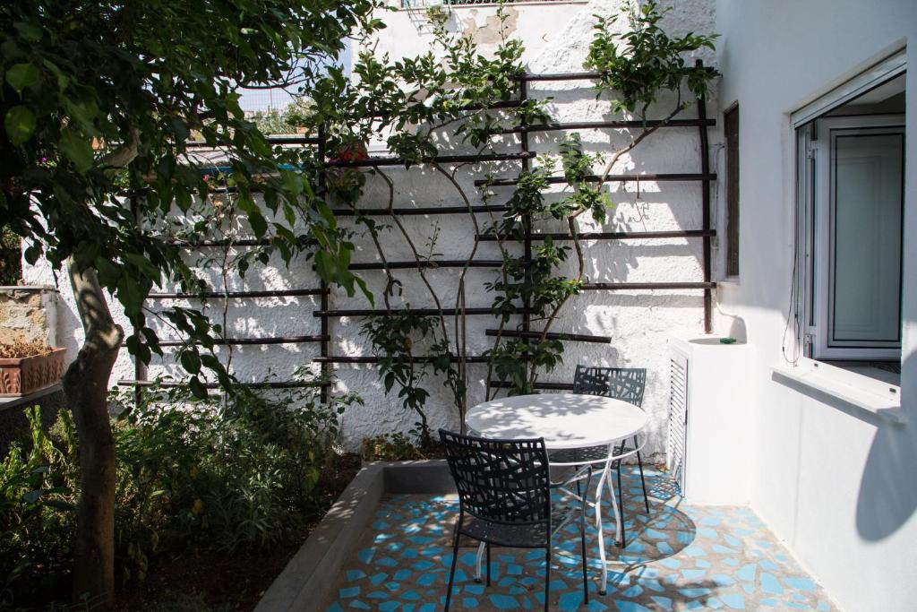 a patio with a table and chairs next to a wall at La Casetta di Sotto in Forio d'Ischia