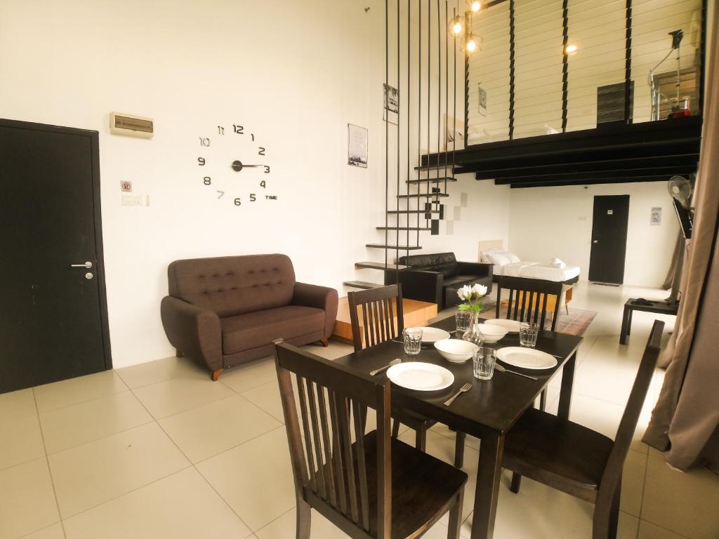 a dining room with a table and chairs and a couch at Colonial9 Suite (Sunrise & Mountain View)@Empire City in Petaling Jaya