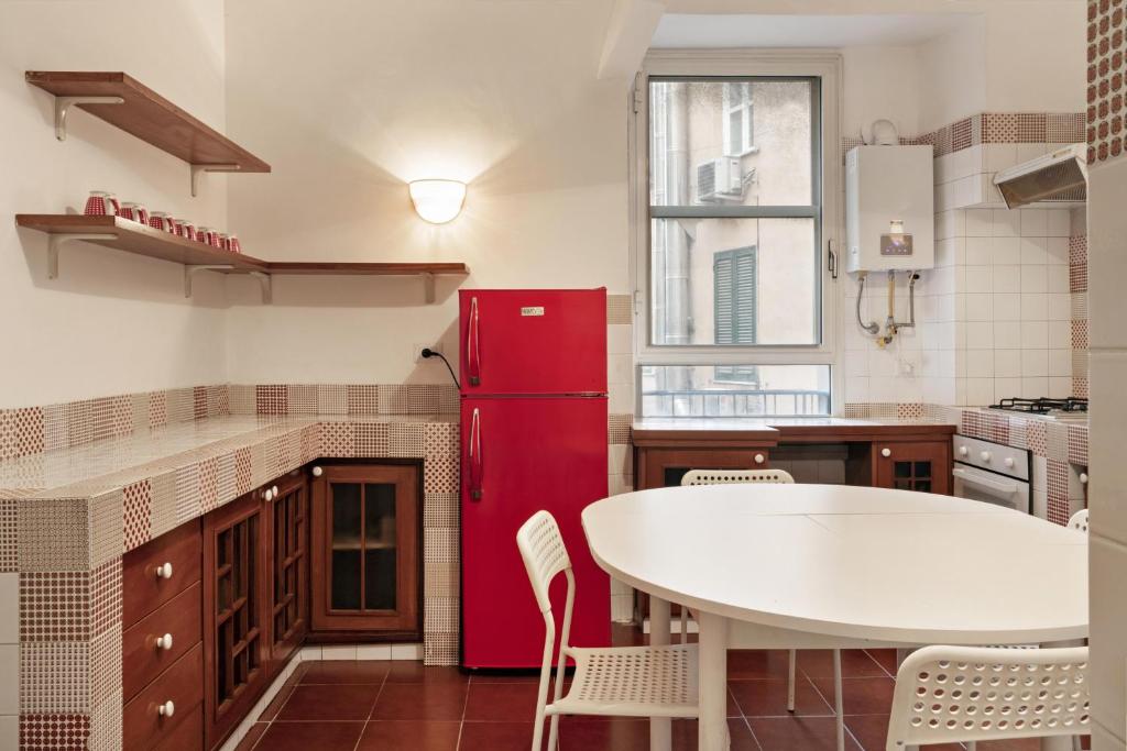 cocina con mesa blanca y nevera roja en Vatican Welc-Home, en Roma