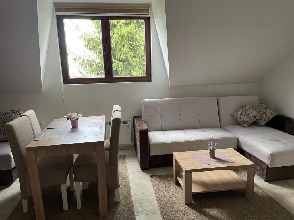 un soggiorno con un divano e un tavolo di Kraljevi Konaci -Apartmani Bajka a Kopaonik