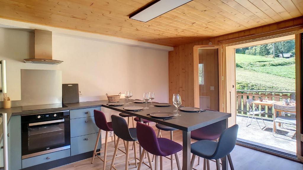 une cuisine avec une table avec des verres à vin dessus dans l'établissement Joli APPARTEMENT DANS CHALET AVEC TERRASSE - SAINT JEAN D'AULPS - PROCHE MORZINE - 6 PERSONNES - LILOU, à Saint-Jean-dʼAulps