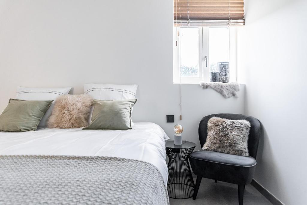 a bedroom with a bed and a chair at Hoeve De Blauwe Zaal in Bruges
