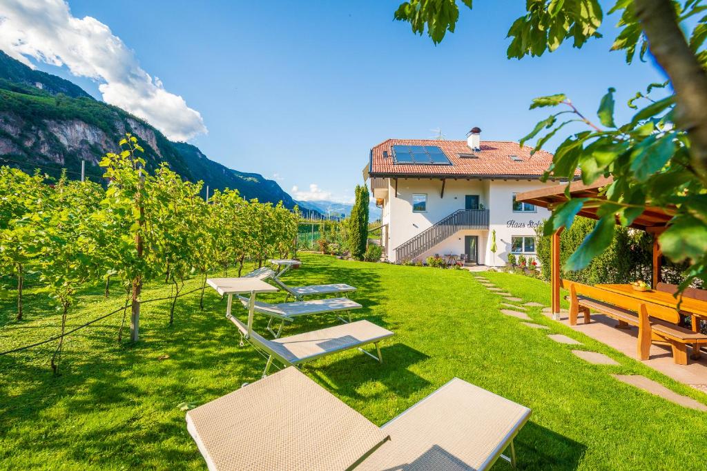 eine Reihe von Bänken im Gras neben einem Gebäude in der Unterkunft Haus Stolz in Appiano sulla Strada del Vino