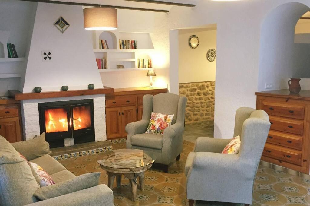 sala de estar con sofás y chimenea en CASA LOLA Naturaleza, Montañas y Piscina Compartida De Pueblo, en Carroja