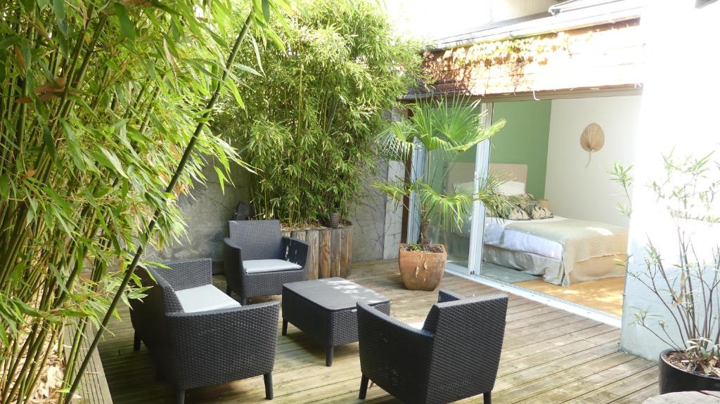 a patio with chairs and a table and some plants at Les Suites Angevines in Angers