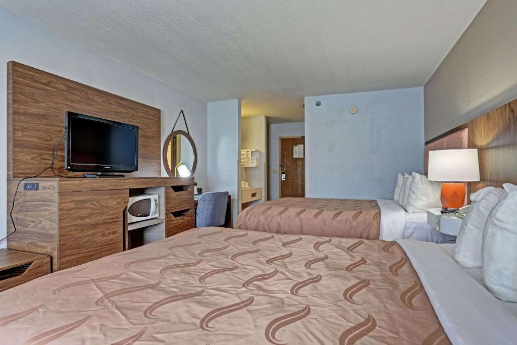 a hotel room with two beds and a flat screen tv at Quality Inn Pierre-Fort Pierre in Pierre