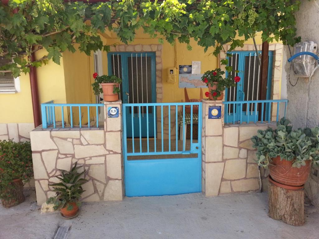 un cancello blu di fronte a una casa con piante di Vintage House-Vori-Rent Rooms a Vóroi