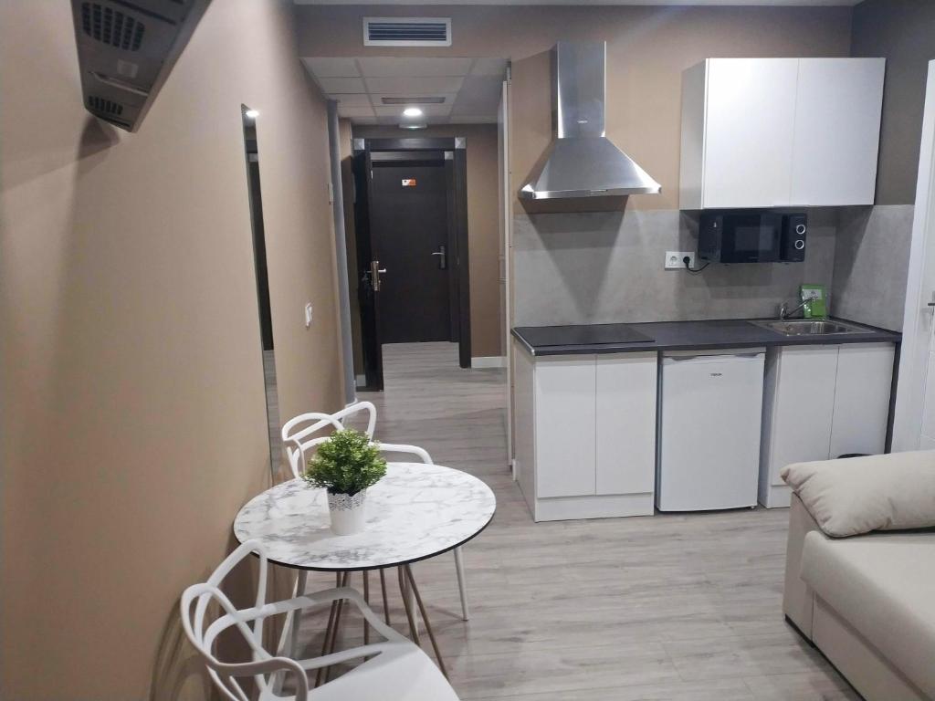 Il comprend un salon avec une table et une cuisine. dans l&#39;établissement Apartamentos Hi Apartaments Santander 3000, à Maliaño