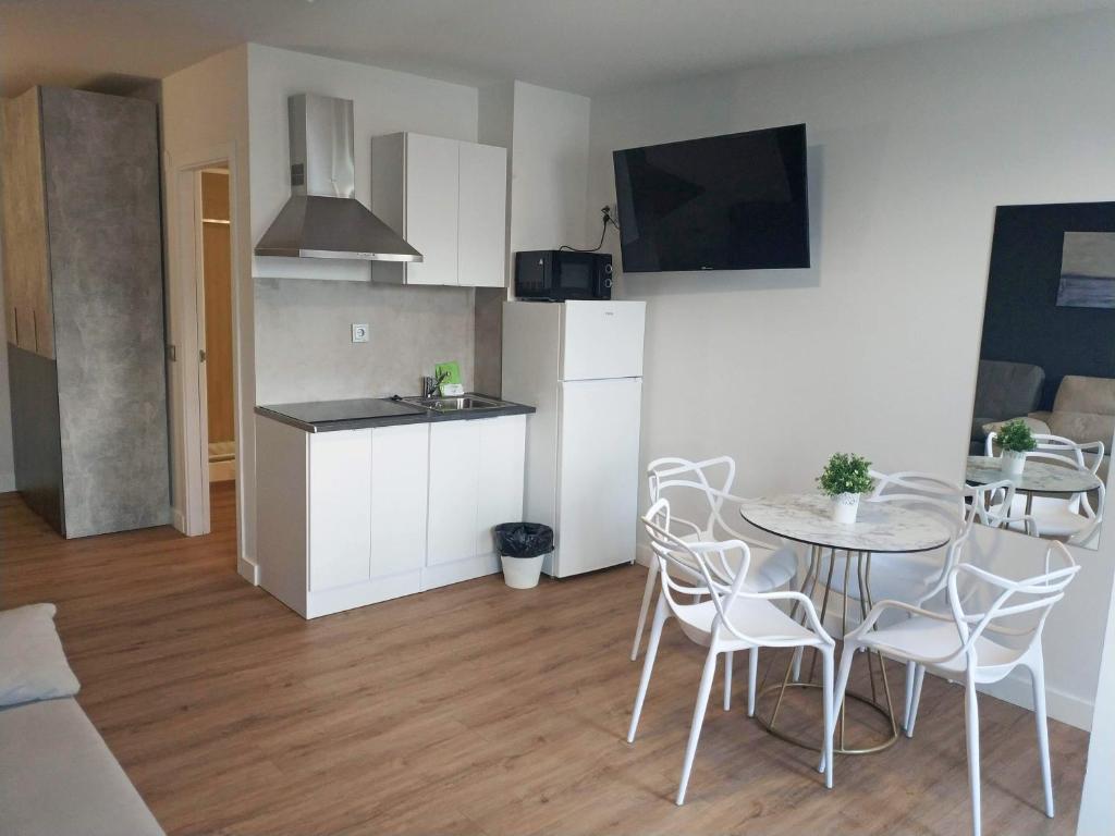 - une cuisine et une salle à manger avec une table et des chaises dans l&#39;établissement Apartamentos Hi Apartaments Santander 3000, à Maliaño