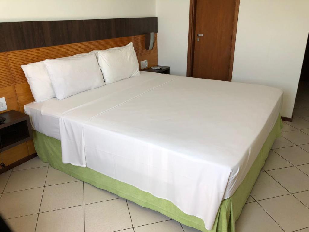 - un grand lit blanc dans une chambre d'hôtel dans l'établissement FLAT NATAL PLAZA, à Natal