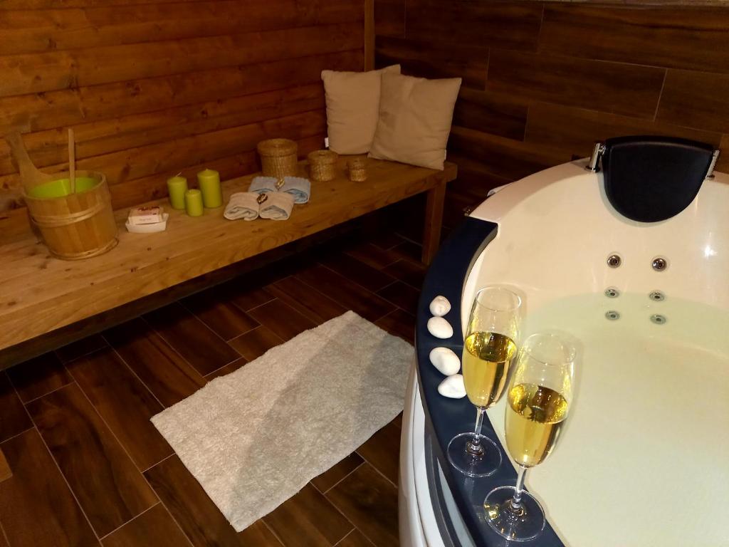 a bathroom with two glasses of wine and a tub at Apartman Nada in Fužine