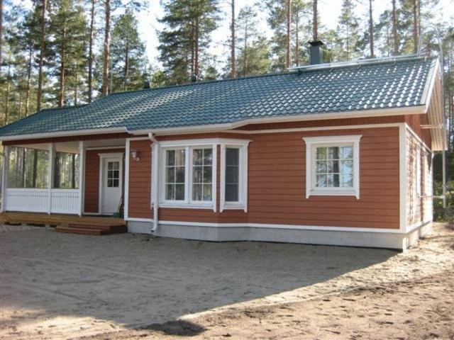 a small red house with a lot of windows at Ruoke Holiday Village in Kesälahti