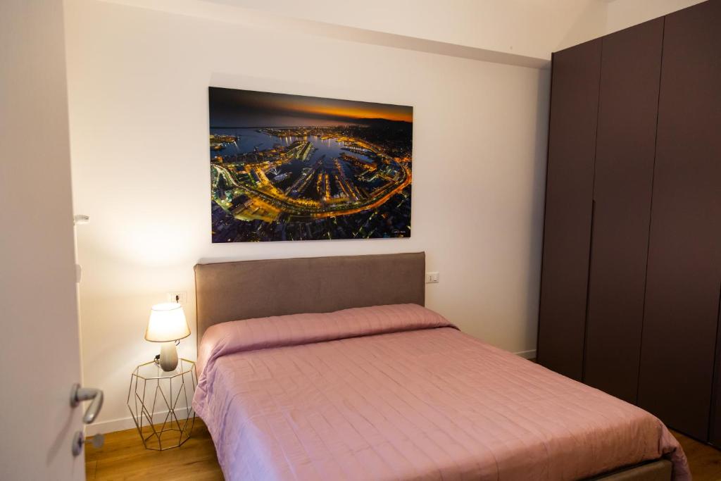 a bedroom with a bed and a painting on the wall at Appartamento Cristoforo Colombo in Genoa