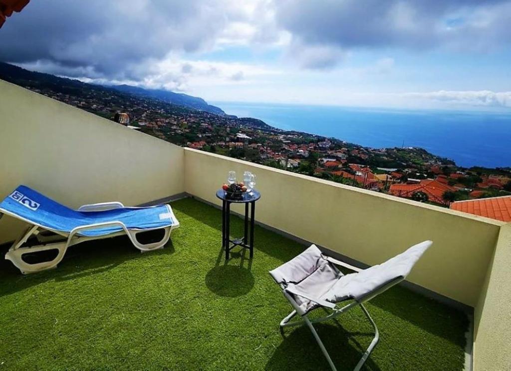 a balcony with a table and chairs and the ocean at Casa AIDA SEA VIEW in Relógio do Poiso