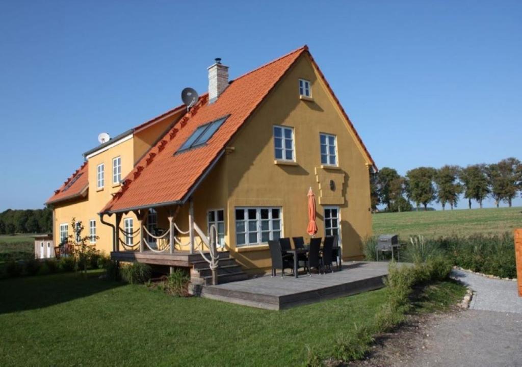 a large yellow house with a red roof at Ferienhaushälfte Nordlicht in Krummin