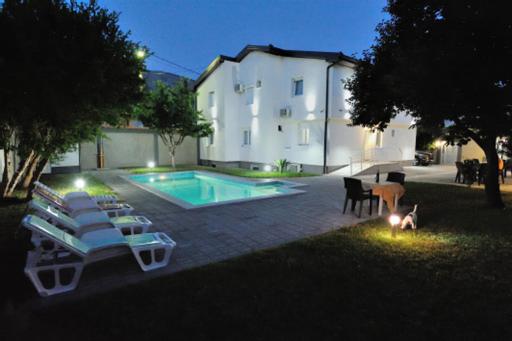 una piscina con tumbonas junto a un edificio en Villa Paradiso By Italy en Mostar