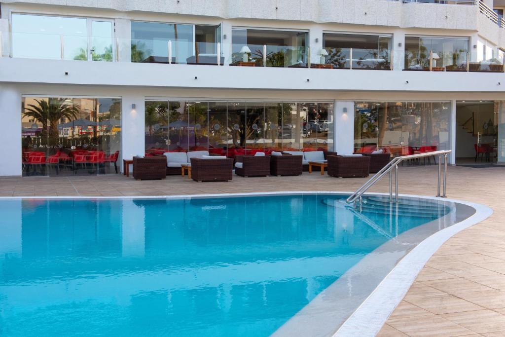 a swimming pool in front of a building at Olé Tropical Tenerife Adults Only in Playa de las Americas