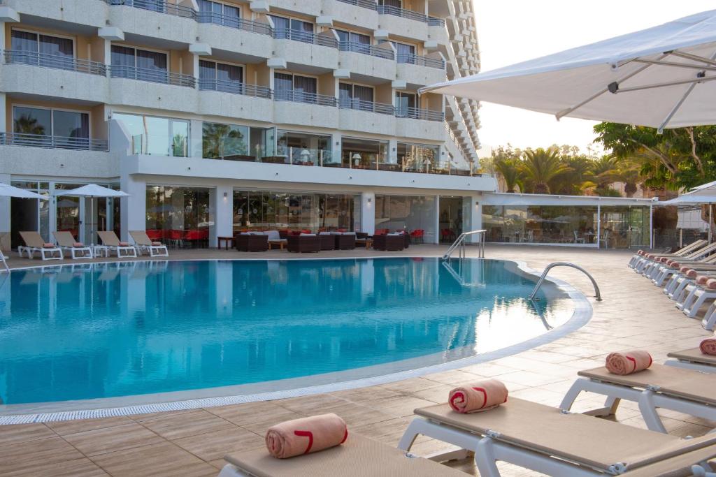 a swimming pool in front of a hotel at Olé Tropical Tenerife Adults Only in Playa de las Americas