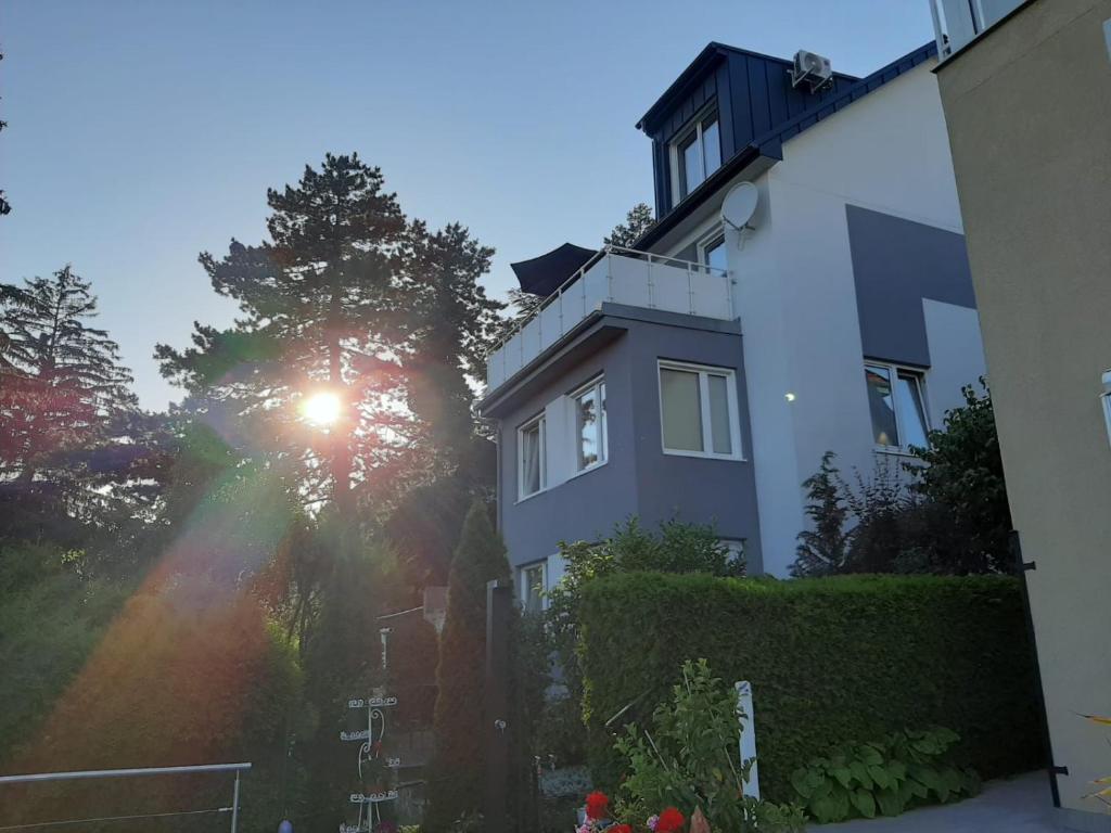a white house with the sun shining on it at Haus Apricum - schön wohnen & gratis parken in Vienna